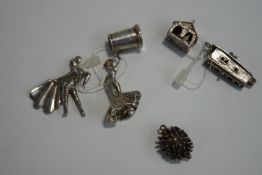 A collection of six silver and silver coloured charms