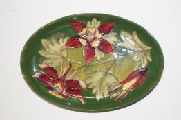 A William Moorcroft oval dish decorated with honeysuckle, painted WM and impressed marks to base,