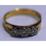 A three stone diamond ring, stamped 18ct, illusion set with small brilliant cuts, finger size P1/2,