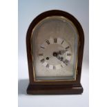 An Edwardian mahogany domed top mantel clock, housing an eight day movement,