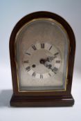 An Edwardian mahogany domed top mantel clock, housing an eight day movement,