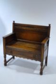 An early 20th Century oak hall bench, with drawer to seat, carved scroll detail,