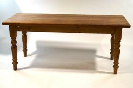 A rectangular pine kitchen table with one frieze drawer on turned legs, 76.