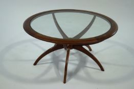 A G-Plan 'spider leg' round coffee table with glass inset top,
