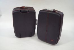 A pair of unused Mulberry suitcases, black with dark brown leather trim and luggage labels,