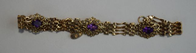 A 9 carat gold amethyst bracelet, the three scroll set motifs to gate links, with a padlock clasp,