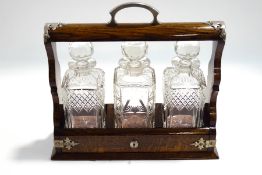 An early 20th century oak three decanter tantalus,