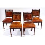 A set of four late Victorian mahogany and leather seated chairs