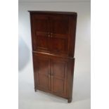 A George III oak free standing corner cabinet, in two sections,