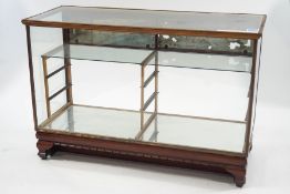 An early 20th Century shop display counter with glass shelves,
