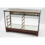 An early 20th Century shop display counter with glass shelves,