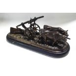 A bronze figure group of two calves pulling a plough, on an oval ebonised plinth,