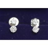 A pair of two stone diamond ear studs,