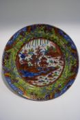 A 19th century Chinese plate with clobbered decoration, depicting a pagoda within a landscape,