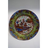 A 19th century Chinese plate with clobbered decoration, depicting a pagoda within a landscape,