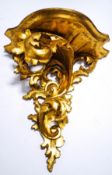 A carved gilt wall bracket with scroll supports