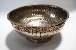 An Indian copper and silver plated bowl, decorated with two bands of scrolling foliage, 23.