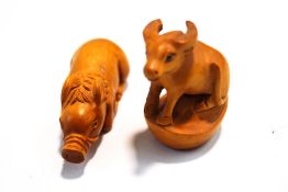 Two carved wooden Netsuke, a water buffalo and a pig,