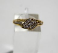 A diamond triple-channel cross-over ring, with diamond five stone shoulders,