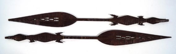 A pair of African tribal paddles, the shafts carved as crocodiles,