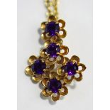 A 9 carat gold amethyst pendant, the five stones to five flowerhead motifs, on a chain,