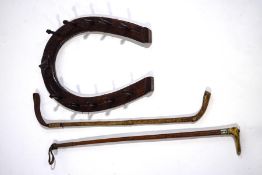 A late 19th century oak riding crop rack, in the form of a horseshoe,