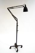 An Anglepoise floor lamp on a four pronged base with casters