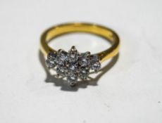 A nine stone diamond 18 carat gold cluster ring, 2001, the brilliant cuts totalling approximately 0.