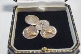A pair of silver cufflinks, one oval panel with a pheasant in flight,