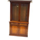 A Victorian mahogany display cabinet with two glazed doors above two frieze drawers above two