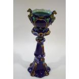 A Victorian majolica jardiniere moulded with dragon handles together with a stand moulded with