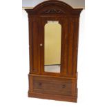 A 19th Century mahogany wardrobe with arched and carved cornice above a mirrored door and one