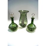 A pair of Mary Gregory type green glass decanters with matched stoppers, 23cm high,