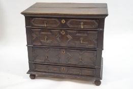 A 17th Century oak chest of four long drawers, with applied geometric mouldings, on bun feet,