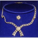 A 9 carat gold collar, with two detachable central starburst motifs, one set with a diamond,