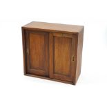 An early 20th Century Hobbs & Co mahogany cabinet with sliding doors, enclosing four shelves, 77.