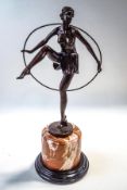 An Art Deco style bronze, modelled as a semi nude dancing girl holding a hoop, after D.