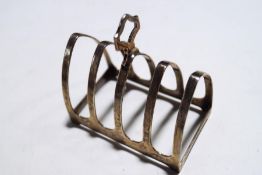 A silver toast rack with four lancet shaped divisions, hallmarks for Sheffield 1933 by E Viner,