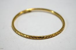 A hinged bangle, stamped '905', with diamond cut decoration, of hollow round section, 3mm wide,