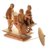 A Boxwood Figural Group Carved to depict a couple riding a cart draped with red fabric and pushed by