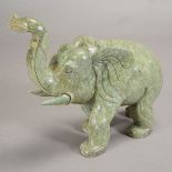 A Carved Hardstone Figure of an Elephant Shown walking with it's trunk held towards the sky, the