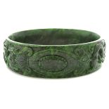 Jade Bracelet. The carved jadeite jade bangle bracelet measuring approximately 24 mm in width,