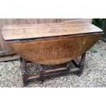 A Queen Anne oak gate leg oval table on turned legs