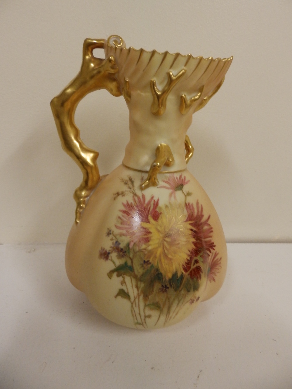 A Royal Worcester floral painted jug with gilt branchiform handle