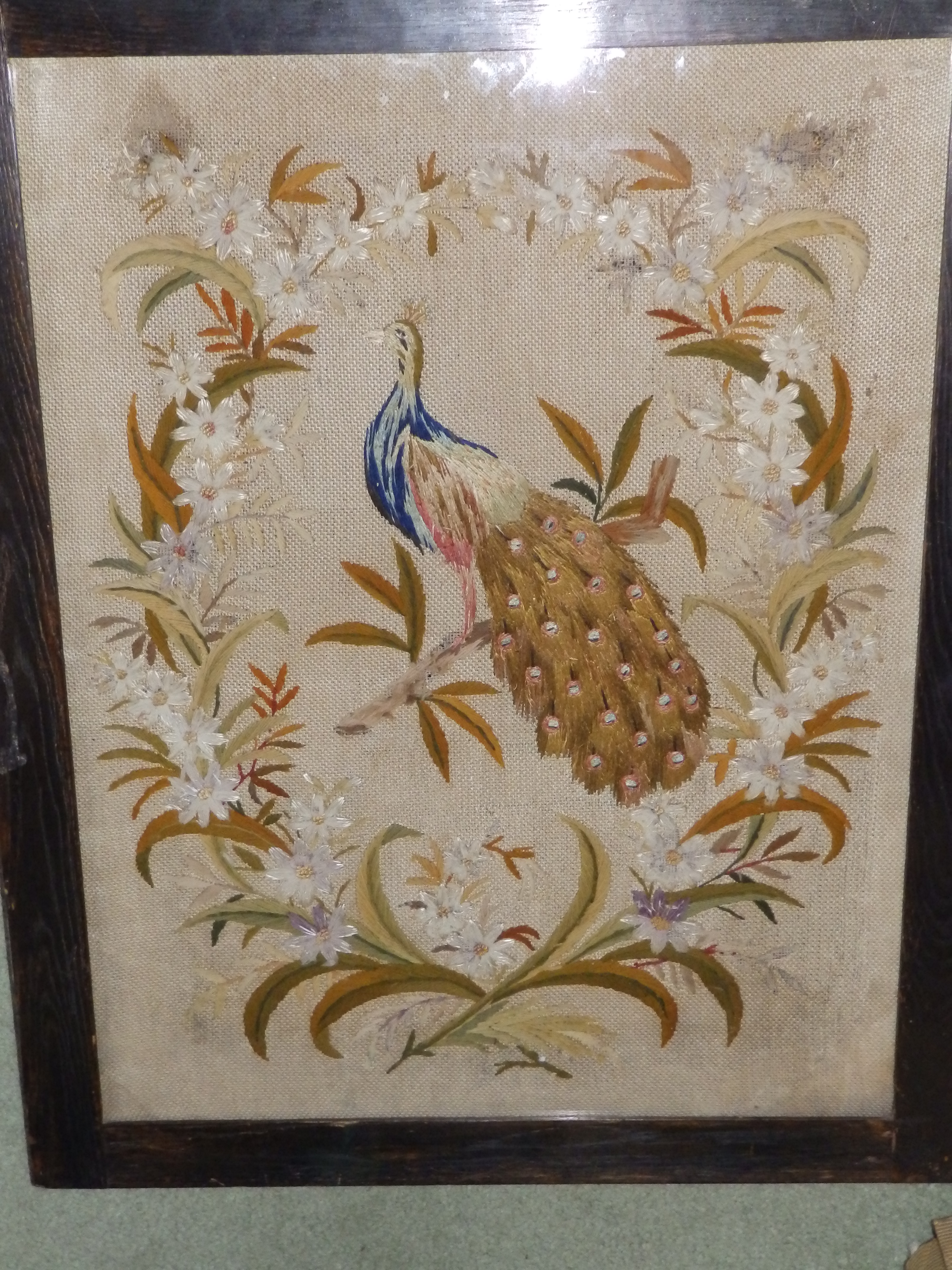 An embroidered silk panel depicting a peacock
