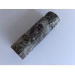 A hardstone cylinder bead carved with a stylised faces and festoons, 2.25”