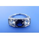 A three stone sapphire & diamond ring, the central round cut sapphire flanked by two old cut