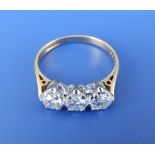 A three stone diamond ring, the claw set brilliant cut stones of total weight approximately one