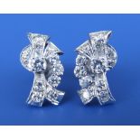 A pair of diamond set swag earrings in white metal with screw backs, 0.70” across