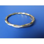 An 18ct gold spiral twist bangle set with numerous small diamonds